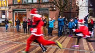 Burlington, Vermont / USA - December 2,2018: the blur of runners dressed as Santa Claus running 5 km for charity in town