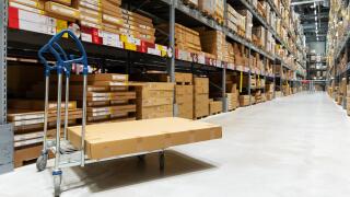 warehouse logistics - box on trolley in modern distribution center