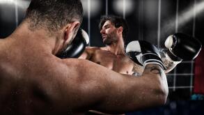 Boxer punches his opponent during boxing competition