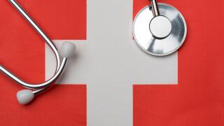 Swiss flag and stethoscope. The concept of medicine. Stethoscope on the flag in the background.