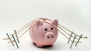 A PIGGY BANK  SECURED WITH ROPE AND NAILS RE SECURE BANKING,BANKS,SAFE,FINANCE SAVINGS THE ECONOMY WAGES MONEY RECESSION CASH UK