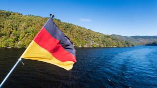 German flag on a boat on Lake Rursee with blue sky and sunlight in summer.