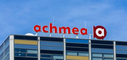 A modern office building featuring the prominent Achmea logo against a clear blue sky. Leiden, Netherlands, 3 May 2025.