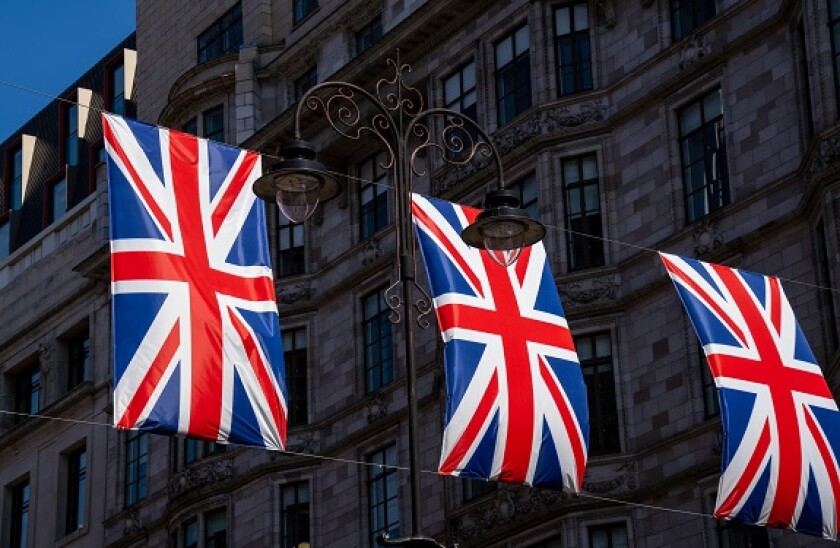 Union Jack flags flying, bunting, on a busy London city street. The red, white and blue UK flags are a symbol of freedom and pride for the people.