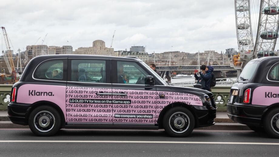 Black taxis with pink Klarna poster in Westminster London, UK