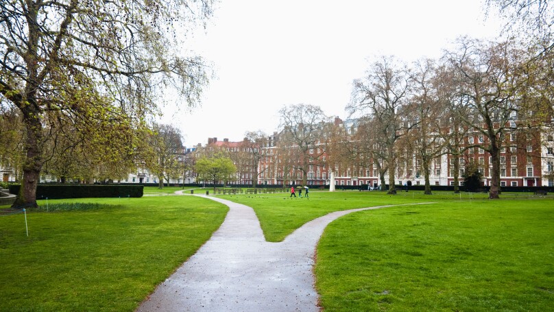Grosvenor Square, London, W1.  A path diverging - becoming two narrow paths - each going in different directions. UK.