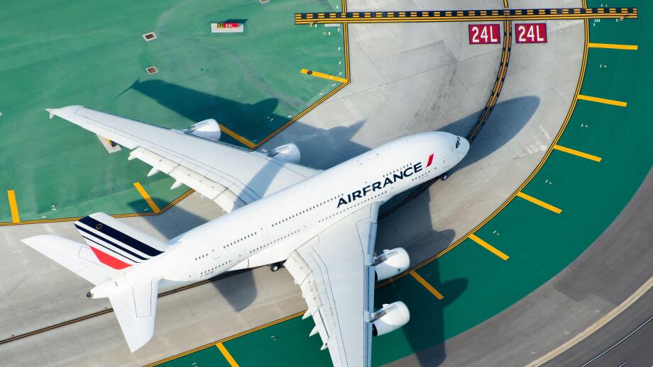 Aerial view of Air France Airbus A380-800 registered as F-HPJA with international airport colorful taxiway marks and lines. Aircraft entering runway.
