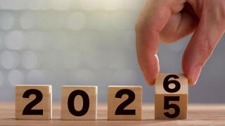 New year change concept. Fingers turning the calendar board block from 2025 to 2026. Graphic poster work for the end and beginning of the year