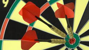 Three Darts in the Bulls Eye on Dart Board.