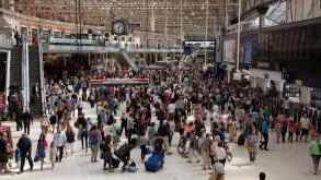 Passengers mingle on a busy London station concourse