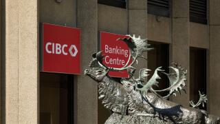 Seal River Crossing statue by sculptor Peter Sawatzky in front of the CIBC logo at Portage and Main, Winnipeg, Manitoba, Canada