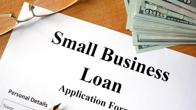 Small business loan form on a wooden table.