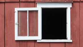 Open window in red barn with white trim as a design element, place your own image in the opening.