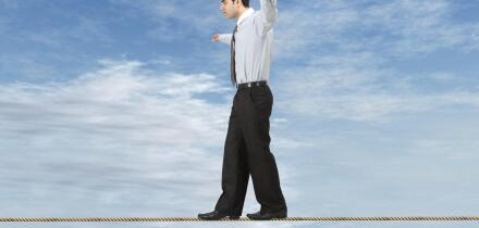 Businessman is balancing on a rope