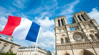 French flag flying in front of Notre Dame Cathedral in Paris, France