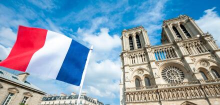 French flag flying in front of Notre Dame Cathedral in Paris, France