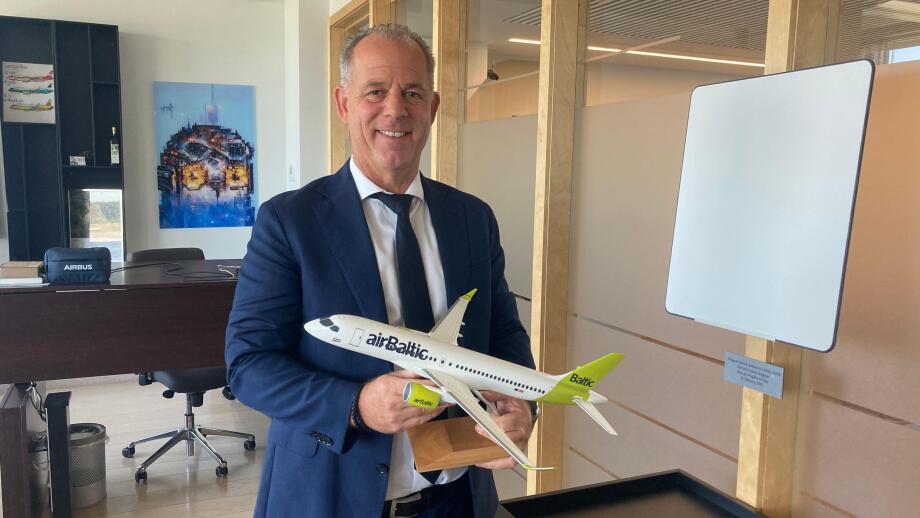 PRODUCTION - 07 June 2023, Latvia, Riga: Martin Gauss, head of Latvian airline Air Baltic, stands in his office with a model airplane in his hand. (to dpa "Air Baltic boss believes climate-neutral flying possible by 2050") Photo: Alexander Welscher/dpa