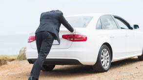 Businessman pushing his car