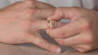 Divorce, separation: man removing wedding or engagement ring