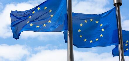 Close up of two European Union Flags flying outside the Berlaymont Building in Brussels, Belgium.