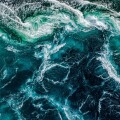 Abstract background. Waves of water of the river and the sea mee
