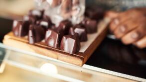 Chocolatier arranging pieces of chocolate on a display case