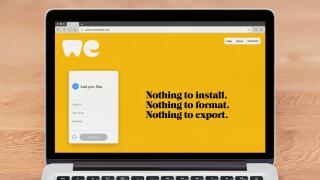 An Apple Macbook displays the WeTransfer website (Editorial use only).