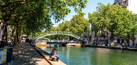 Paris, France, 04.28.2025 People enjoying a warm day on the banks of Canal Saint Martin in the 10th arrondissement of Paris