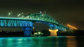 The Auckland Harbour Bridge, Auckland, New Zealand, colorfully lit at night during Auckland Anniversary