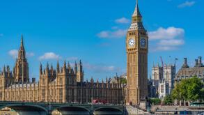 View of Houses of Parliament and Westminster Bridge from Queens Walk during summer in Westminster London England