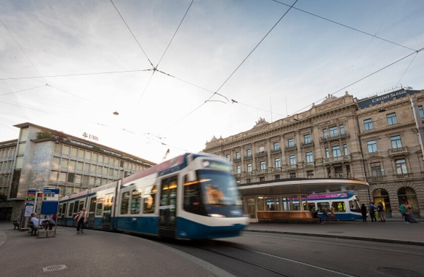 A tramway train is leaving the tram station at Zurich's Paradeplatz with headquarters of the Swiss banks UBS and Credit Suisse