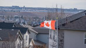 Canadian national Flag Maple leaf flag flying over house roofs in Calgary