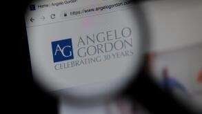 The Angelo Gordon financial website seen through a magnifying glass