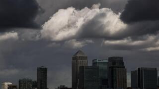 Dark storm clouds over Canary Wharf business park buildings in London