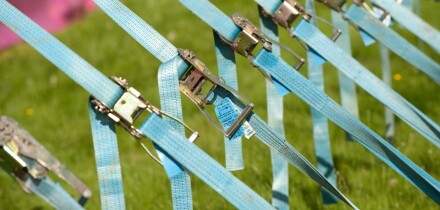 Row of tension tightening straps and pulleys on a large marquee
