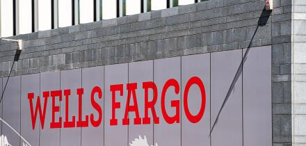 London, UK - June 22, 2018: Closeup of Wells Fargo bank branch entrance with red sign on modern building wall and nobody in England