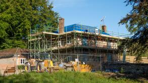 Old farmhouse undergoing extensive renovations viewed from public footpath, Berkshire, England, UK