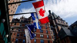 Quebec Flag (Fleur de Lys) and the Canadian flag (Maple Leaf) flying outside the Chateau Frontenac Hotel in Quebec City, Canada