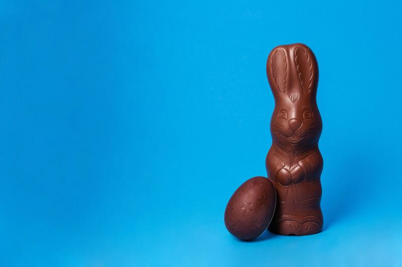 Easter Chocolate Bunny with egg on Blue Background Creative Easter Holiday Concept.jpg