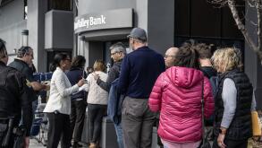 Santa Clara, United States. 13th Mar, 2023. An employee hands out papers to customers queued up for admittance at the collapsed Silicon Valley Bank in Santa Clara, California on Monday, March 13, 2023. President Biden spoke assuring Americans that the U.S