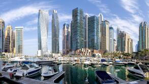 Dubai Marina skyline cityscape with yachts skyscraper real estate buildings living at water panorama boats