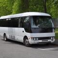 A small white tour coach, bus or mini-van used to transport passengers and tourists. Typically used for small group tours of around 21 passengers.