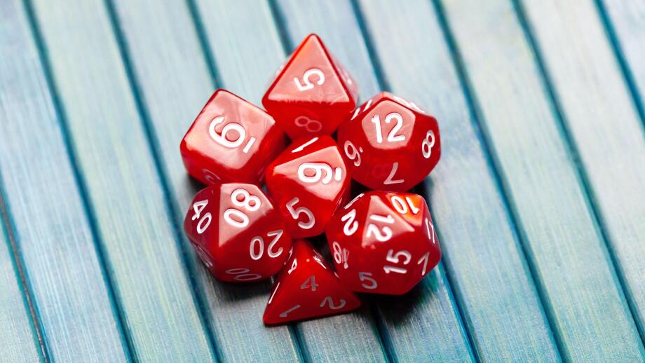 Lots of simple red RPG game dice, polyhedral dice set for role playing games and scenarios, top view. Dices group closeup. Tabletop board games
