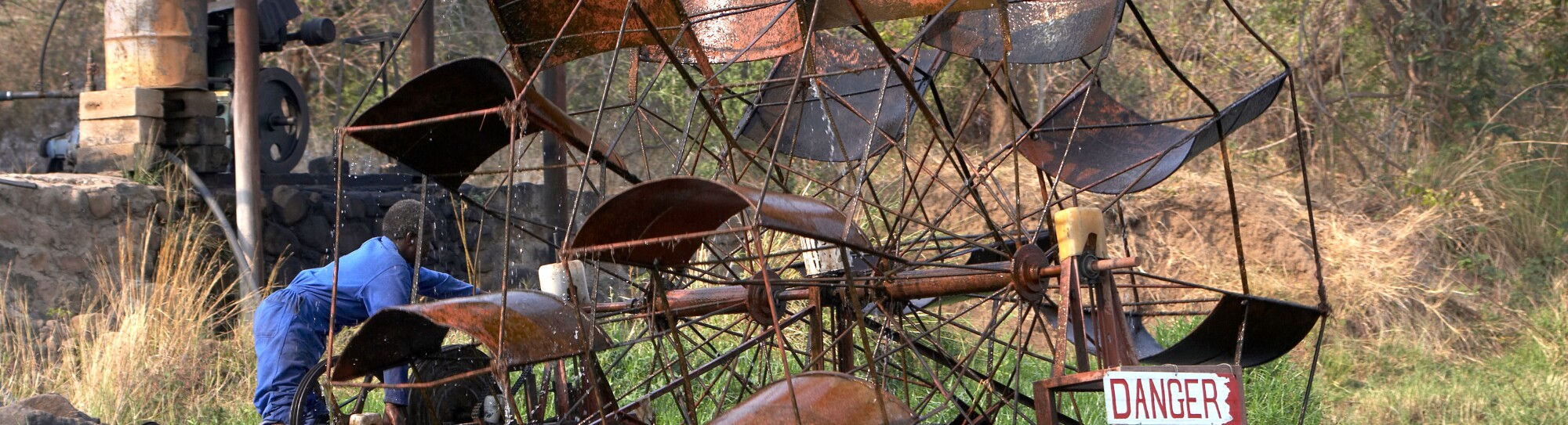 Worker operating a floating waterwheel on the Lower Zambezi River Zambia Zimbabwe Africa