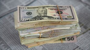 US dollars and financial pages in newspaper