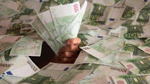 hand with euro banknotes climbs out of a mountain of money