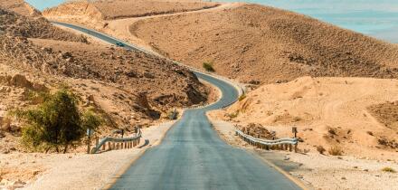 Long desert road stretching. empty asphalt road in the middle of the desert with the nature of the middle East