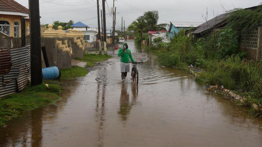 A man wades through a flooded street ahead of the forecasted arrival of Hurricane Melissa in Old Harbour, Jamaica, Monday, Oct. 27, 2025. (AP Photo/Matias Delacroix)