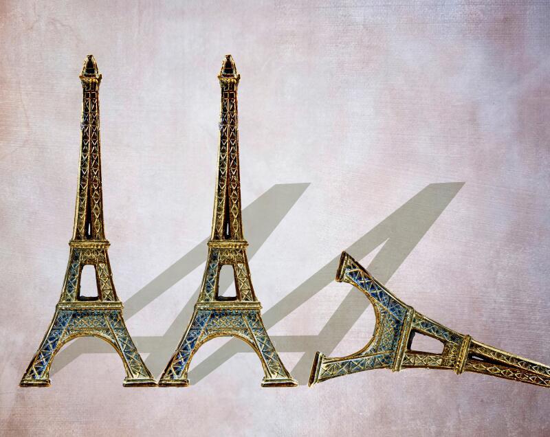 Three miniature Eiffel Towers shaped like the letter A, one toppled over, symbolic image for the French AAA credit rating