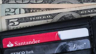Wallet containing Santander and Tesco bank cards, and american dollars.